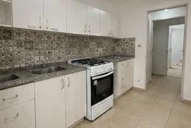 Cocina-comedor con muebles bajo mesada y horno